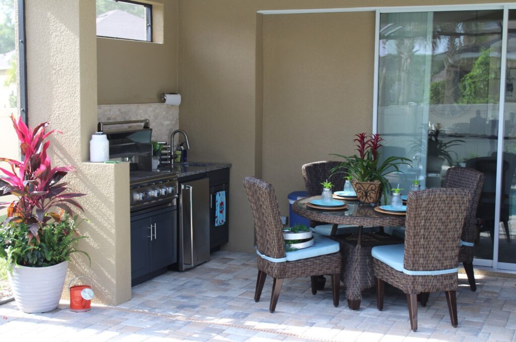 backyard with round table and chairs, grill, sink, and built-in fridge