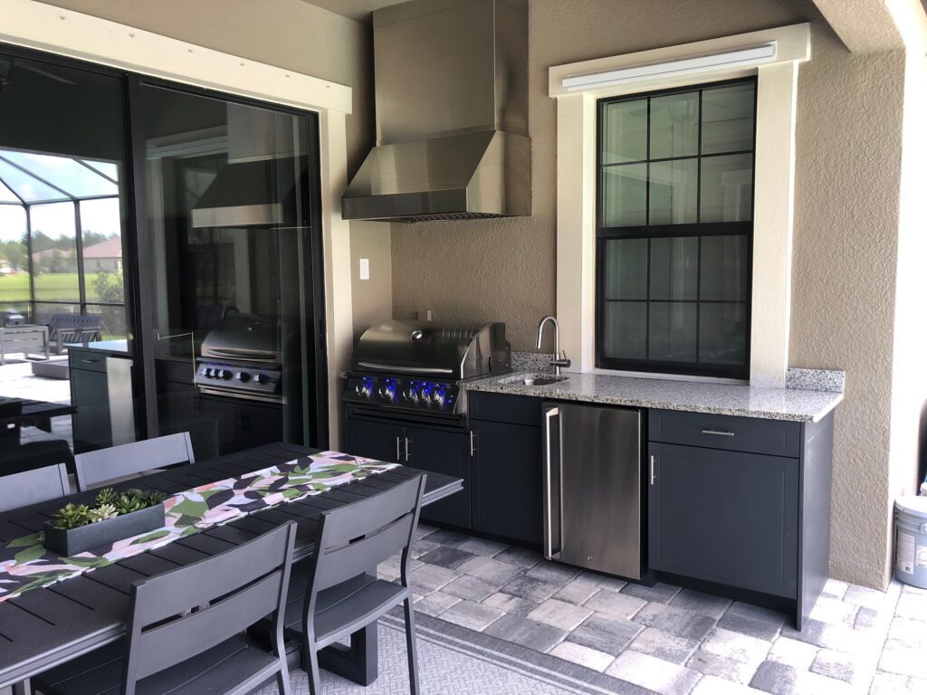 outdoor kitchen charcoal grey cabinets and light granite counters