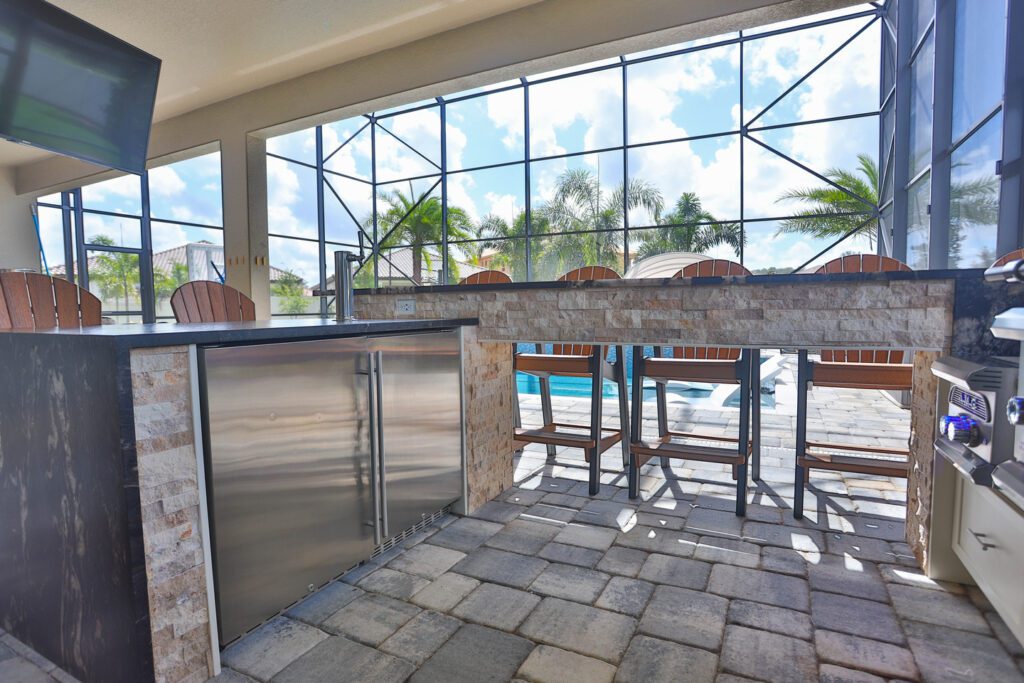 patio kitchen with kegerator, stools, and bar-height counter
