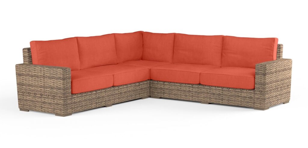 wicker outdoor sectional with orangey cushions 