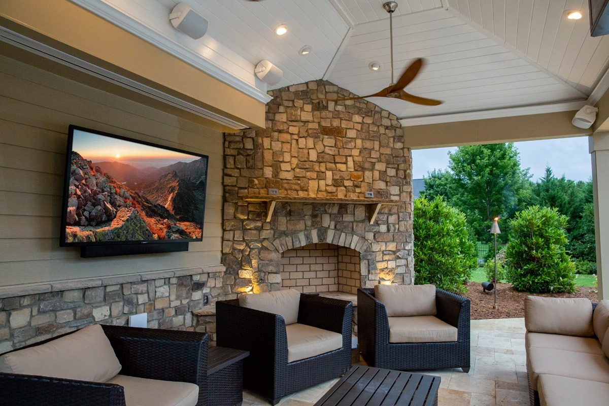 Outdoor TV mounted to wall in outdoor living space