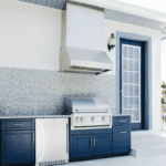 Outdoor kitchen with grill and blue cabinets