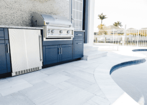Poolside outdoor kitchen with grill and blue cabinets