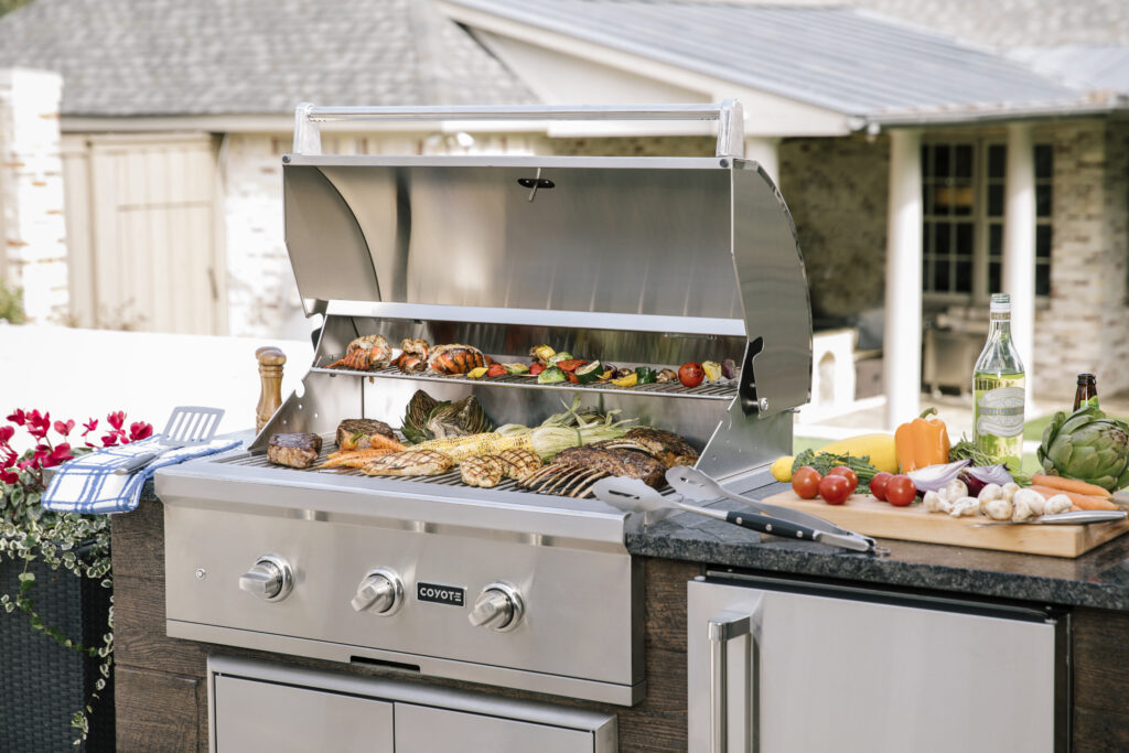 Coyote grill in outdoor kitchen with food