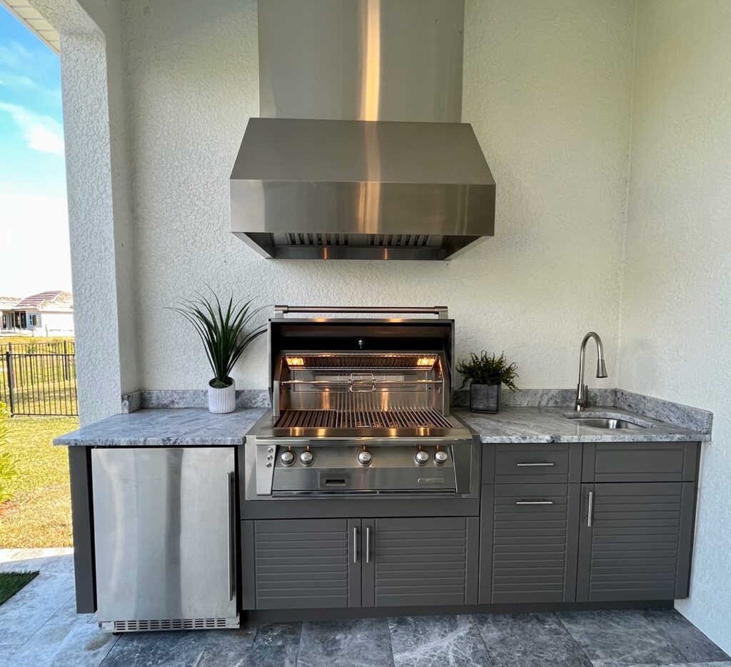 Outdoor kitchen with grill and sink and fridge