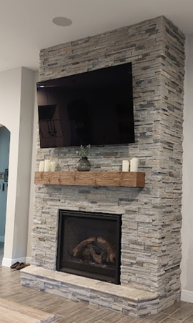 TV and fireplace installed on stone wall