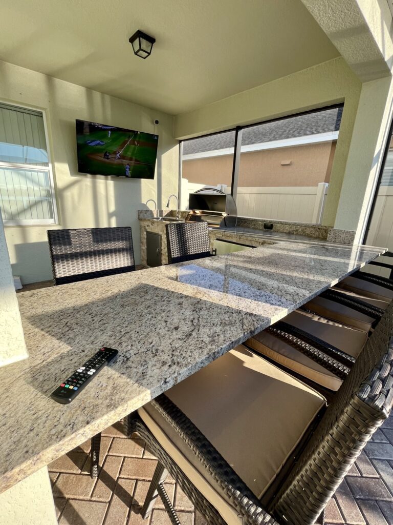 Granite countertops in outdoor kitchen with outdoor TV