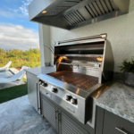 Outdoor kitchen with grill and grill hood