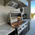 Outdoor kitchen with grill and grill hood