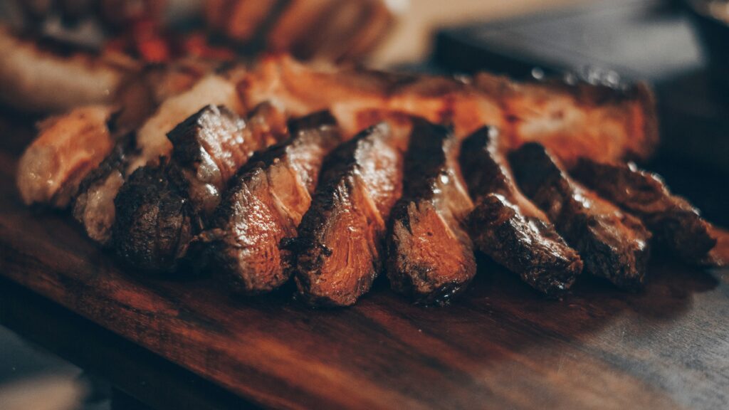 cooked steak on a wooden cutting board 